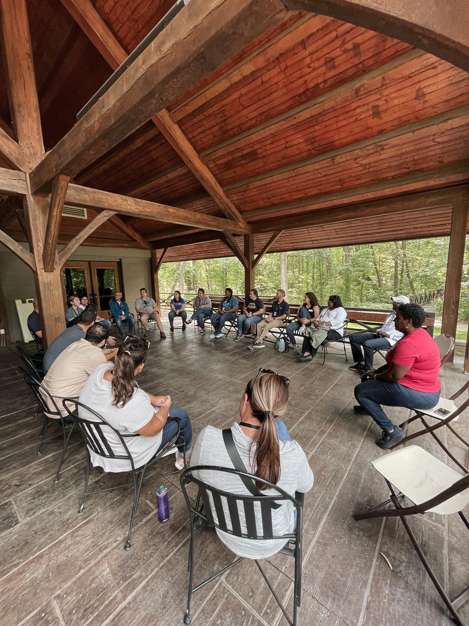Image of people sitting in chairs in a circle while engaged in discussion